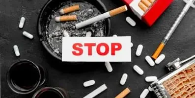 The word stop with pills and cigarettes on the background.