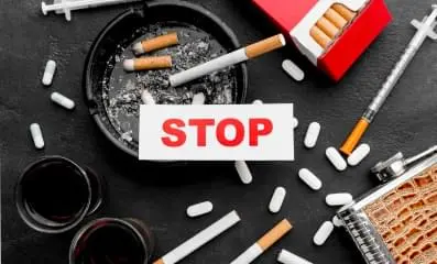 The word stop with pills and cigarettes on the background.