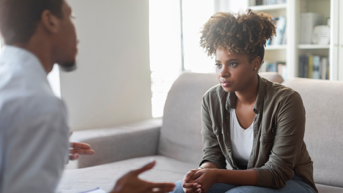 Woman actively listening the her therapist while sitting on a couch