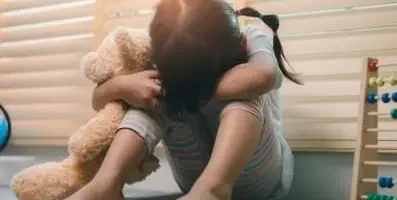 Kid in foster care sad with head down