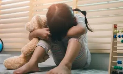 Kid in foster care sad with head down