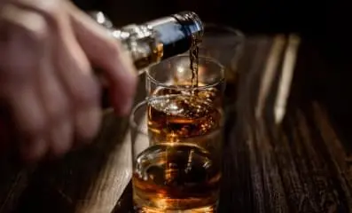 poring alcohol into glass.