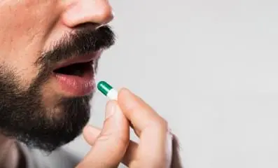 A man taking a pill.