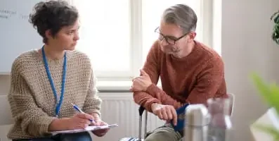 Counselor speaking to man. Alcohol poses risks such as liver damage, cardiovascular issues, and increased susceptibility to various cancers.