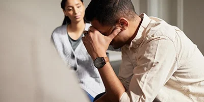 man in distress with his therapist in the background