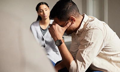 man in distress with his therapist in the background