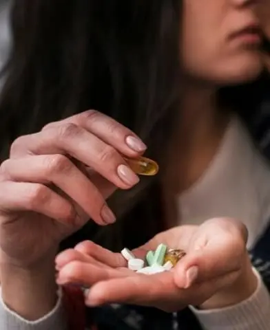 hand holding variety of pills.