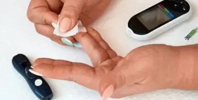 Finger prick test. Text: If you have diabetes, your blood sugar levels may plummet when you are consuming alcohol and taking insulin.