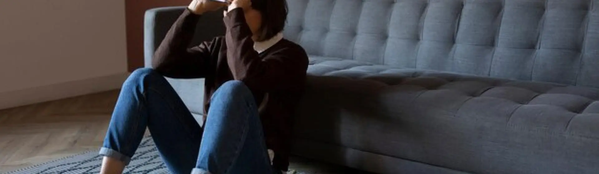 Depressed woman sitting down leading on couch.