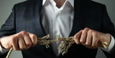 Man pulling apart ropes ripping it.