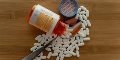 Pills spilled onto a spoon. In 2020 alone, there were over 1,500 opioid-related overdose deaths in the state.