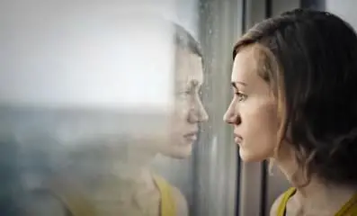 Woman staring outside of window