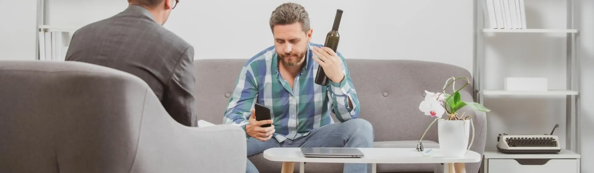 A man at therapy holding a wine bottle