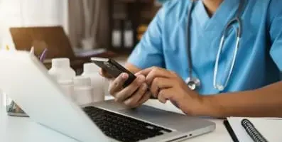Doctor typing on his phone
