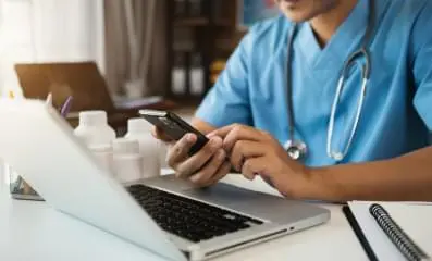 Doctor typing on his phone