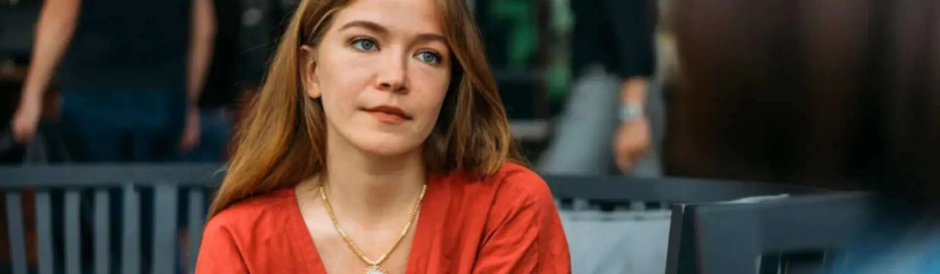A woman daydreaming holding a cup of coffee.