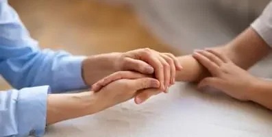 A person holding another person hand in support