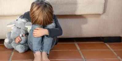 Image: Child crying. Text: Childhood trauma has a negative impact on the brain and physiological reactions throughout the body.