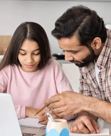 Father helping his daughter with her homework.