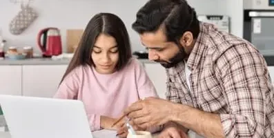 Father helping his daughter with her homework.