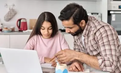 Father helping his daughter with her homework.