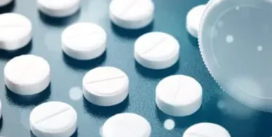 White pills in a row. The use of non-stimulant drugs and behavioral therapies instead of Adderall can help in managing ADHD symptoms.