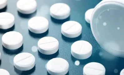 White pills in a row. The use of non-stimulant drugs and behavioral therapies instead of Adderall can help in managing ADHD symptoms.