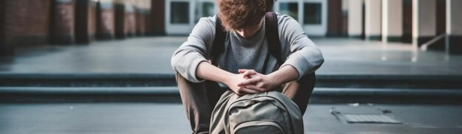 Sad college student looking down.