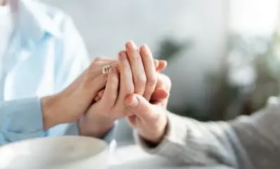 Therapist and patient holding hands.