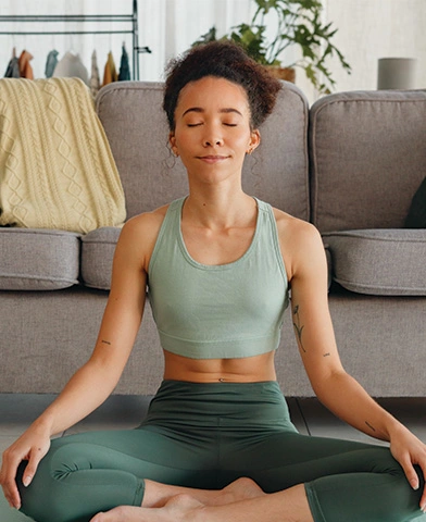 woman meditating peacefully in an all green outfit