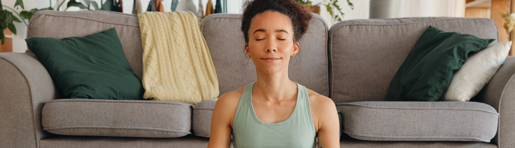 woman meditating peacefully in an all green outfit