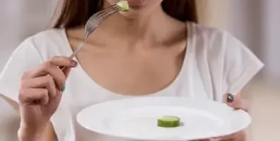 A woman eating one cucumber.