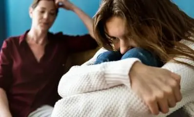 Depressed teen sitting down.