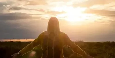 Woman staring at sunrise.