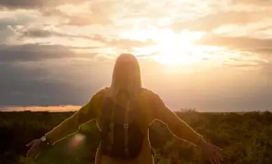 Woman staring at sunrise.