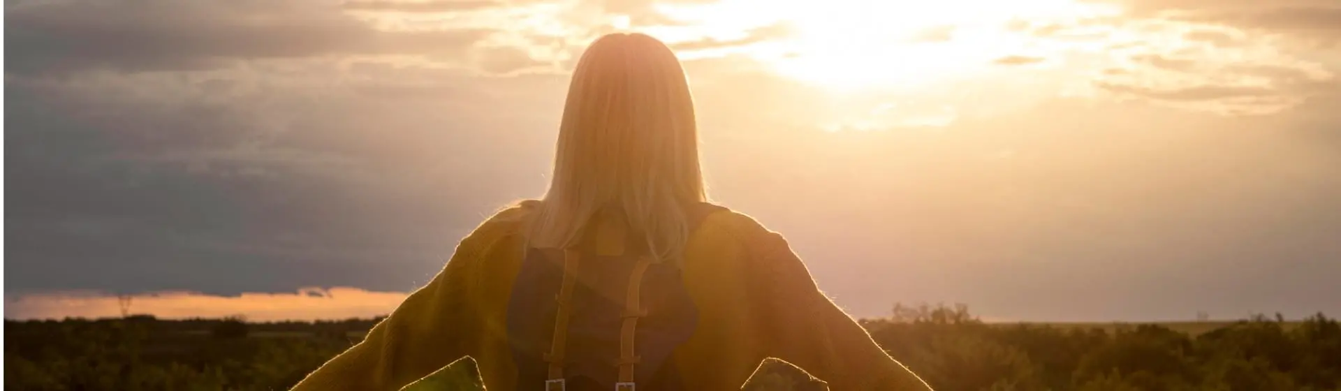 Woman staring at sunrise.