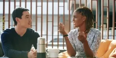 Woman speaking to man over coffee.