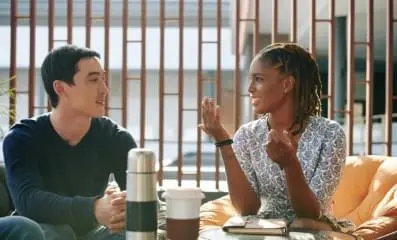 Woman speaking to man over coffee.