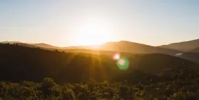 Sunrise over a mountainscape. Natural sunlight and green spaces enhance cognitive functioning and well-being.