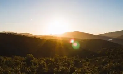 Sunrise over a mountainscape. Natural sunlight and green spaces enhance cognitive functioning and well-being.