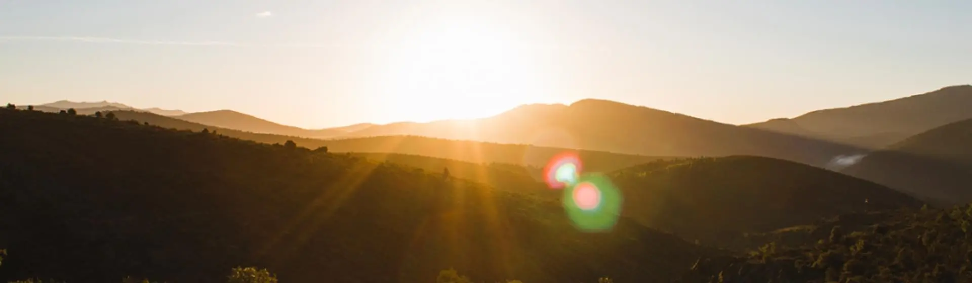 Sunrise over a mountainscape. Natural sunlight and green spaces enhance cognitive functioning and well-being.