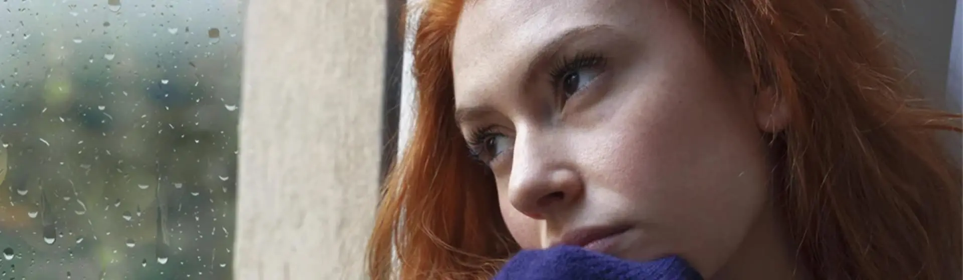 Woman depressed staring outside of window