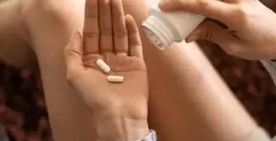 Woman putting pills in her hand from the bottle. Synthetic opioids are lab-manufactured painkillers.