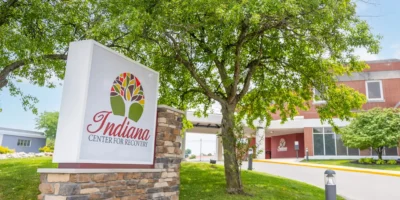 Indiana Center for Recovery South Bend location sign displayed on landscaped grounds outside the brick treatment center building.