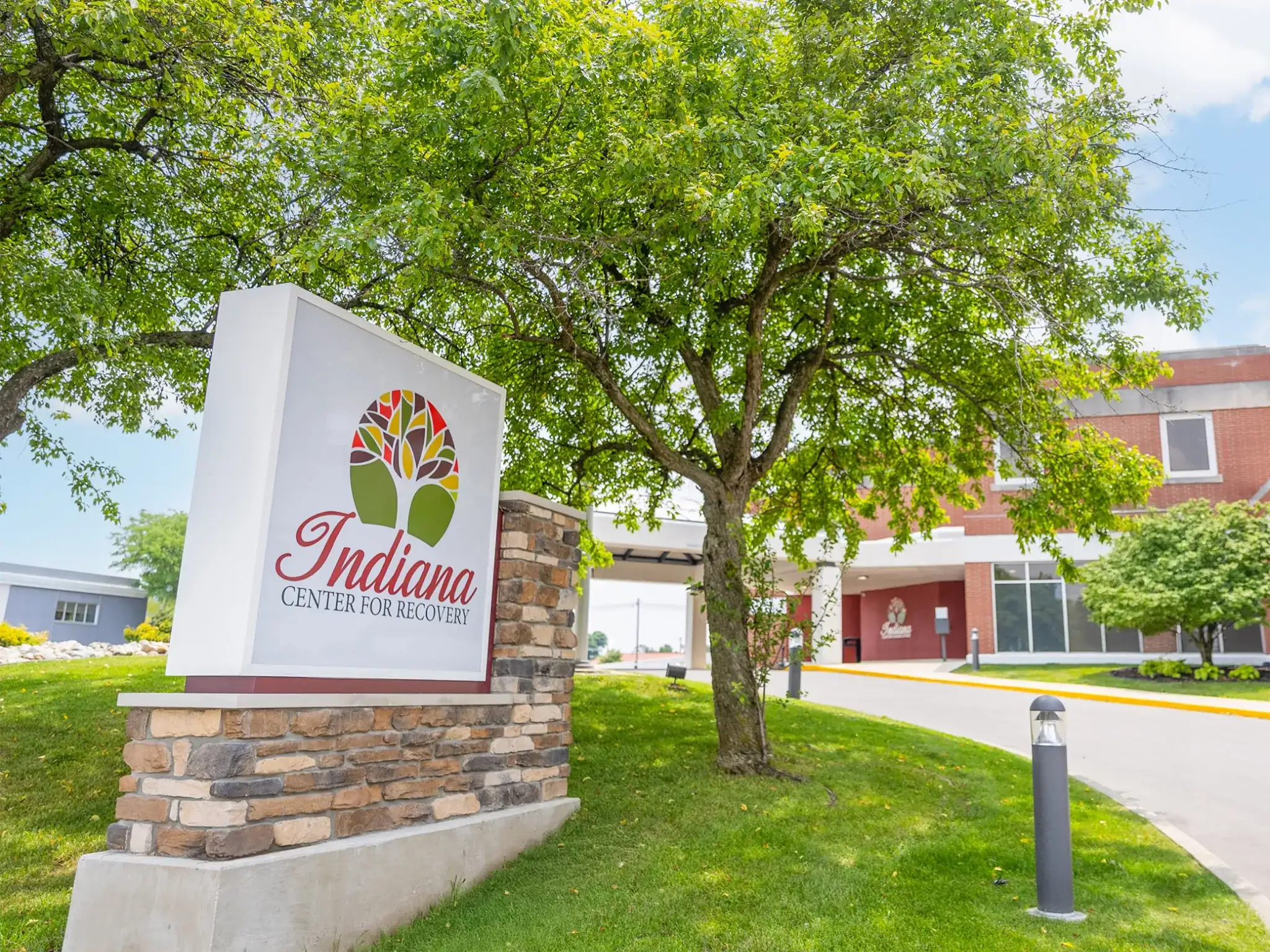 Indiana Center for Recovery South Bend location sign displayed on landscaped grounds outside the brick treatment center building.