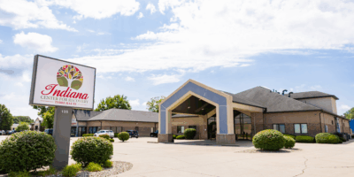 A professional photograph of the exterior of the Indiana Center for Recovery building in Terre Haute, Indiana, featuring the facility's sign with its logo and address number "135" clearly visible.