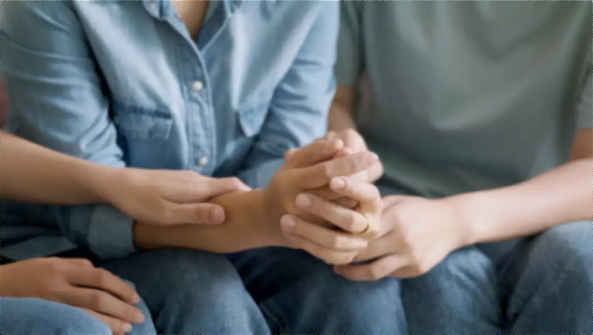 Close-up of family members holding hands, representing support and involvement in addiction recovery at Indiana Center for Recovery.
