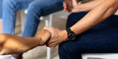 Adults in a circle holding hands. Quality care and specialized programs characterize reputable addiction treatment centers near Illinois.