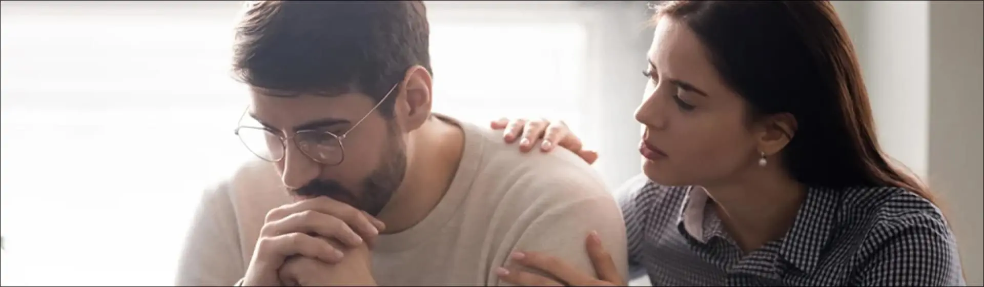 Woman comforting a man. Family involvement and a compassionate community are crucial in guiding individuals through recovery.