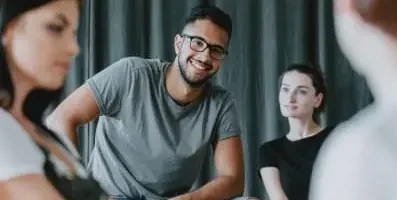 Smiling man in gray shirt. Text: Look for treatment providers who specialize in addressing both drug addiction and mental health disorders.